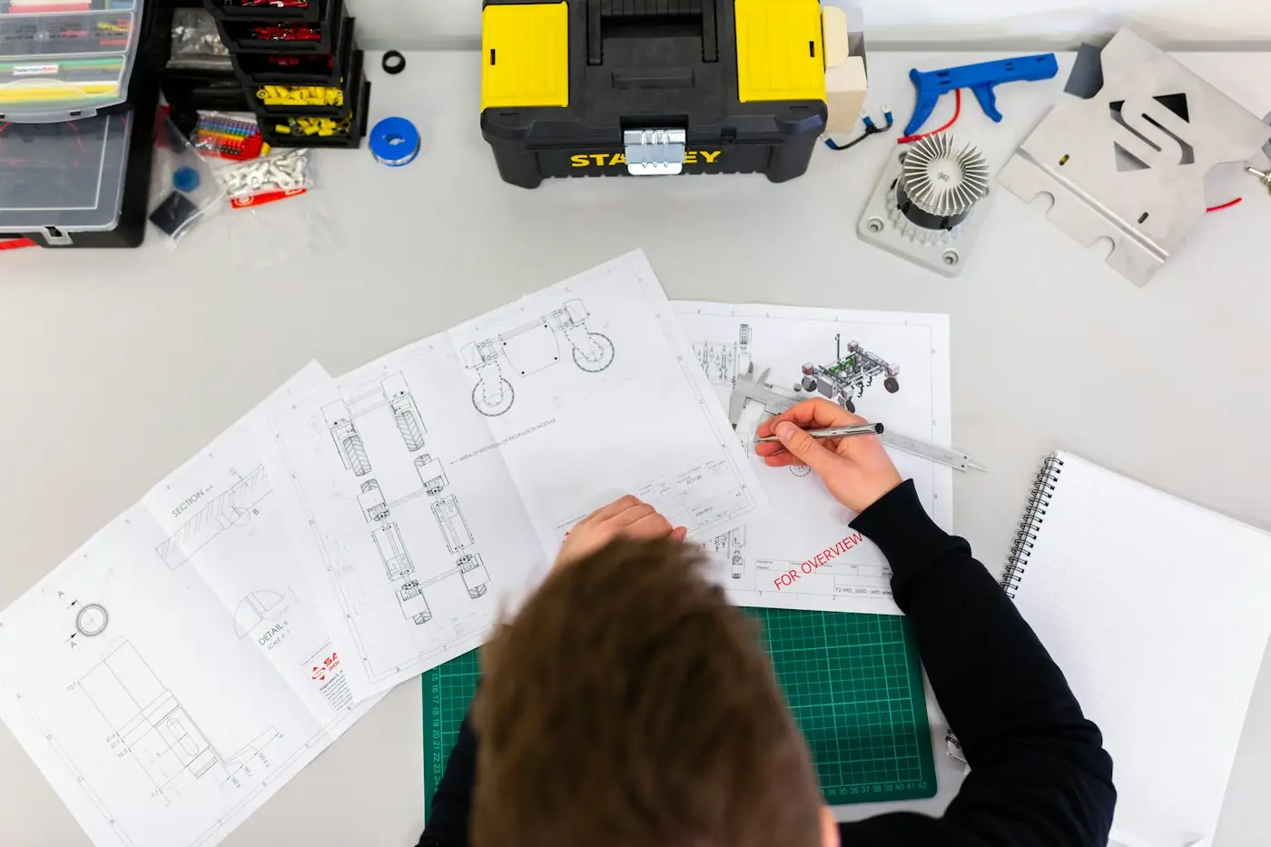 Overhead view of engineering drawings and tools on a desk