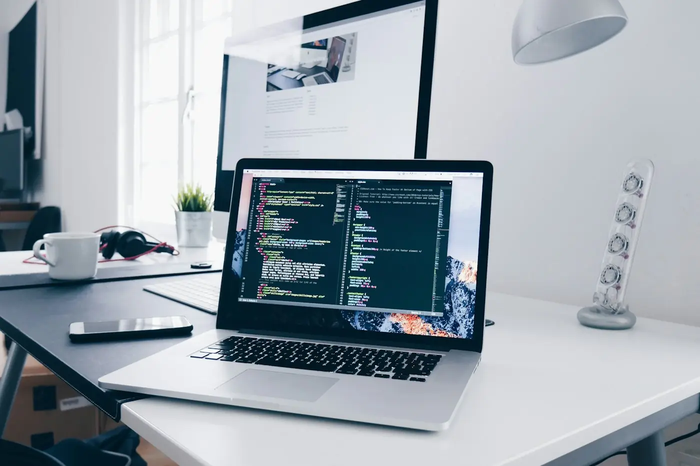 Laptop displaying code on a tidy desk
