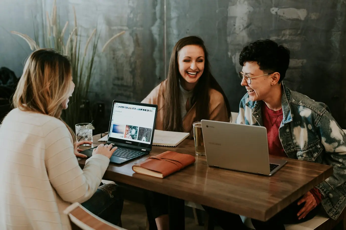 Colleagues collaborating happily around a laptop
