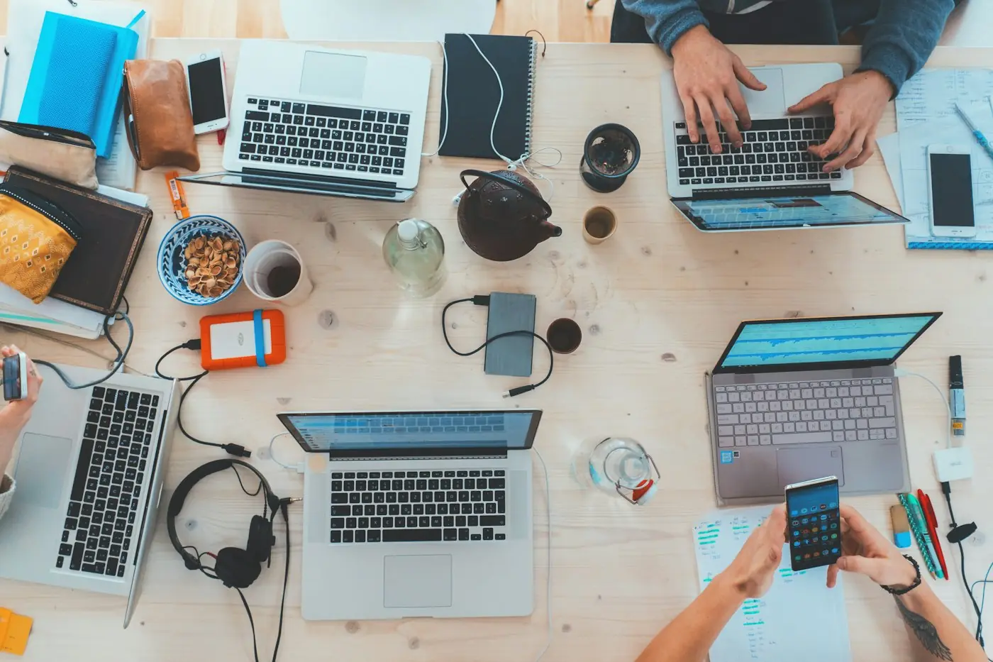 Overhead view of a team planning around a table of laptops